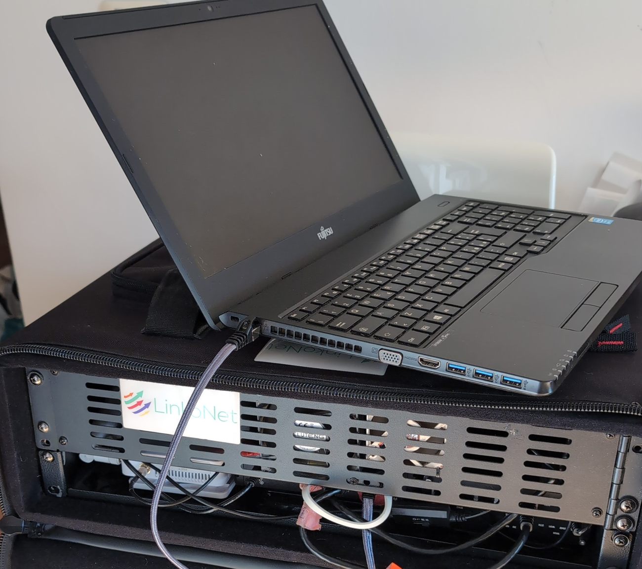 Un kit LinkoNet aperto nella sua valigia rigida, con un portatile collegato appoggiato sopra